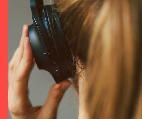 HAUTWENDE: Podcast Ansicht eines linken Hinterkopfes mit Kopfhörern.