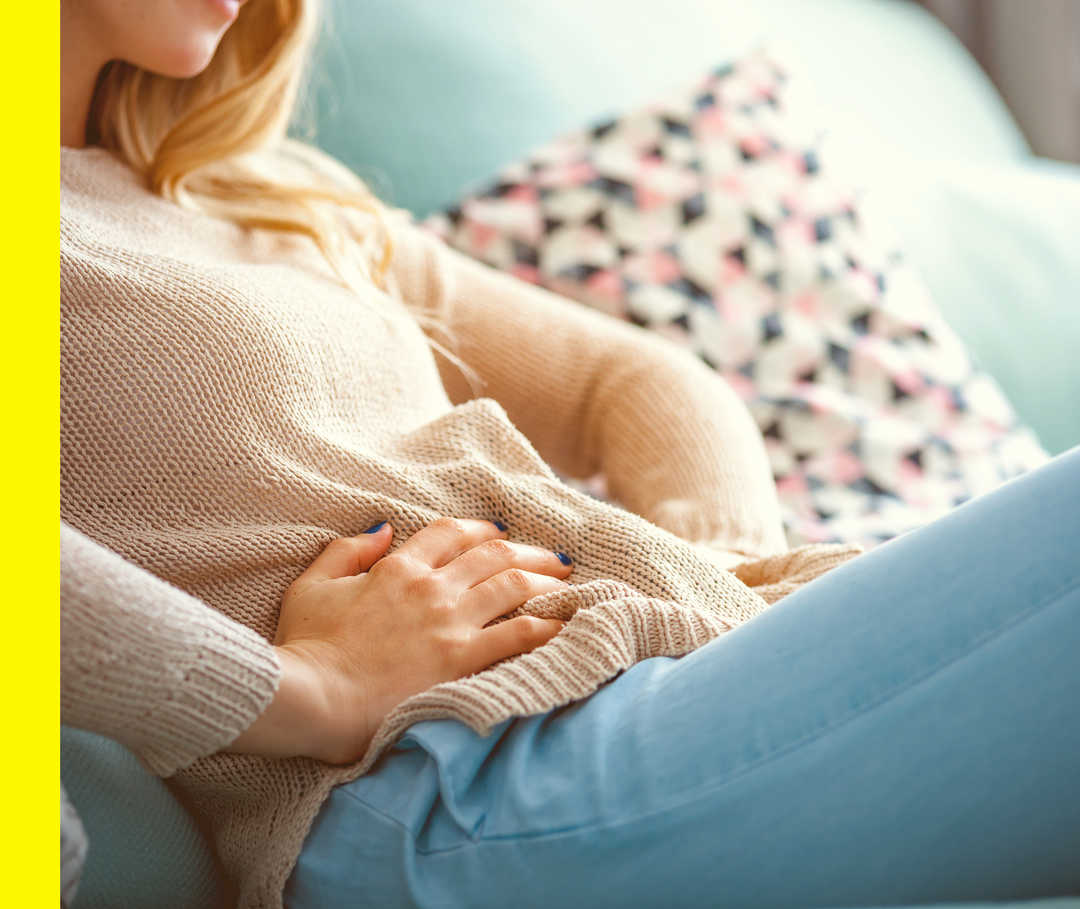 Akne inversa: Begleiterkrankungen Eine Patientin hält sich mit beiden Händen ihren Bauch