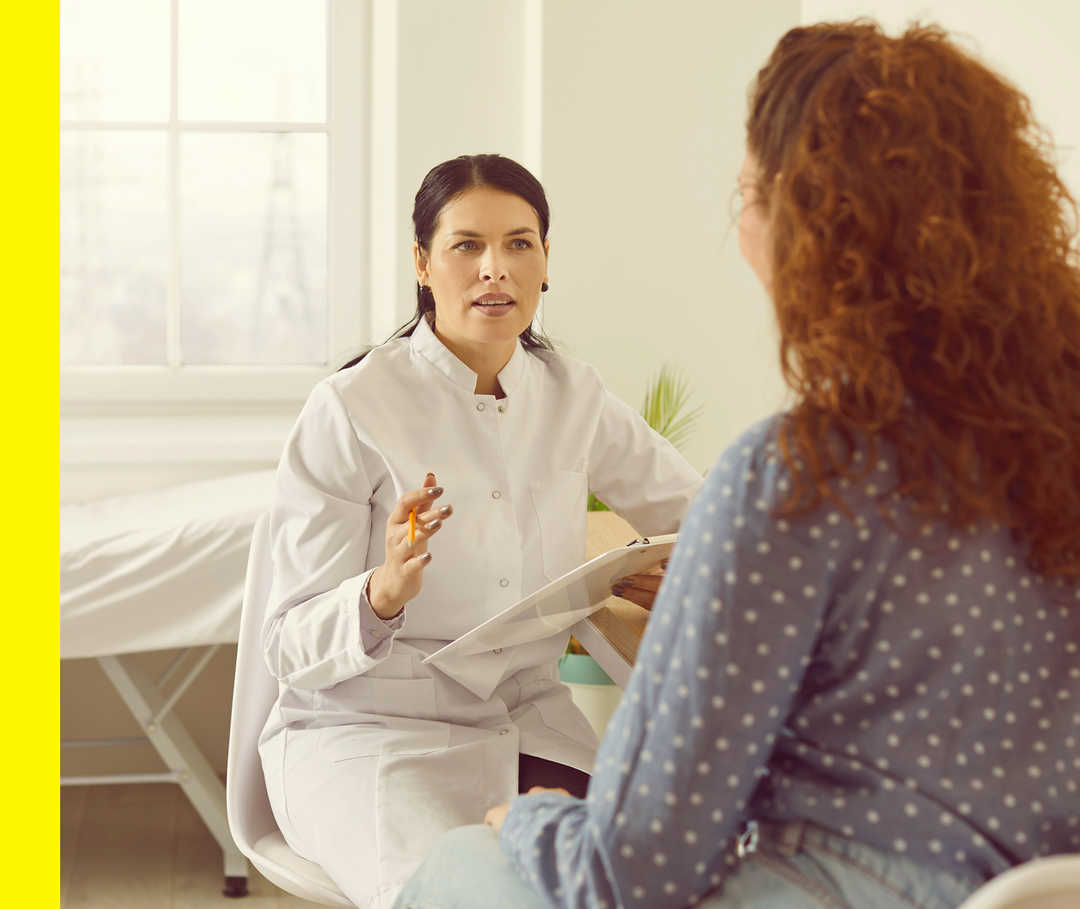 Akne inversa: Tests Scores Eine Ärztin im Gespräch mit einer Patientin