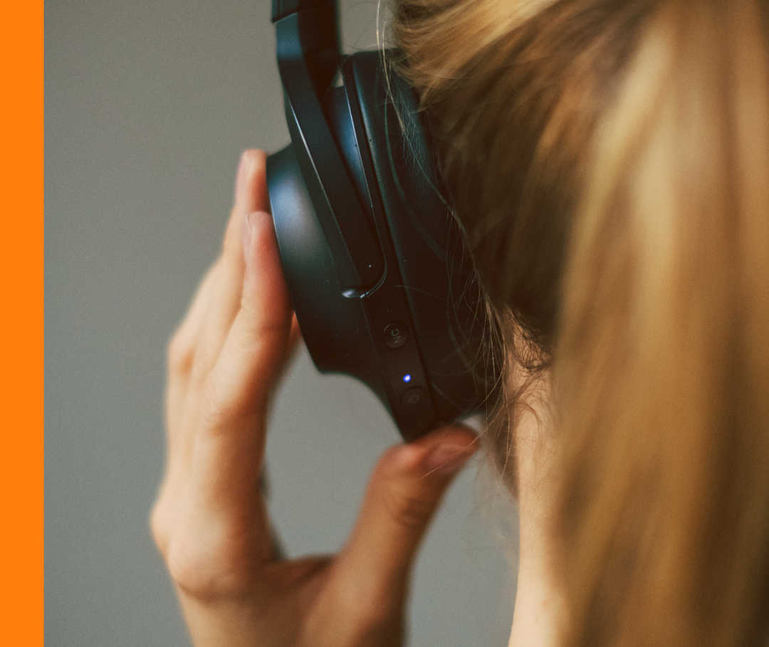 HAUTWENDE: Podcast Ansicht eines linken Hinterkopfes mit Kopfhörern.