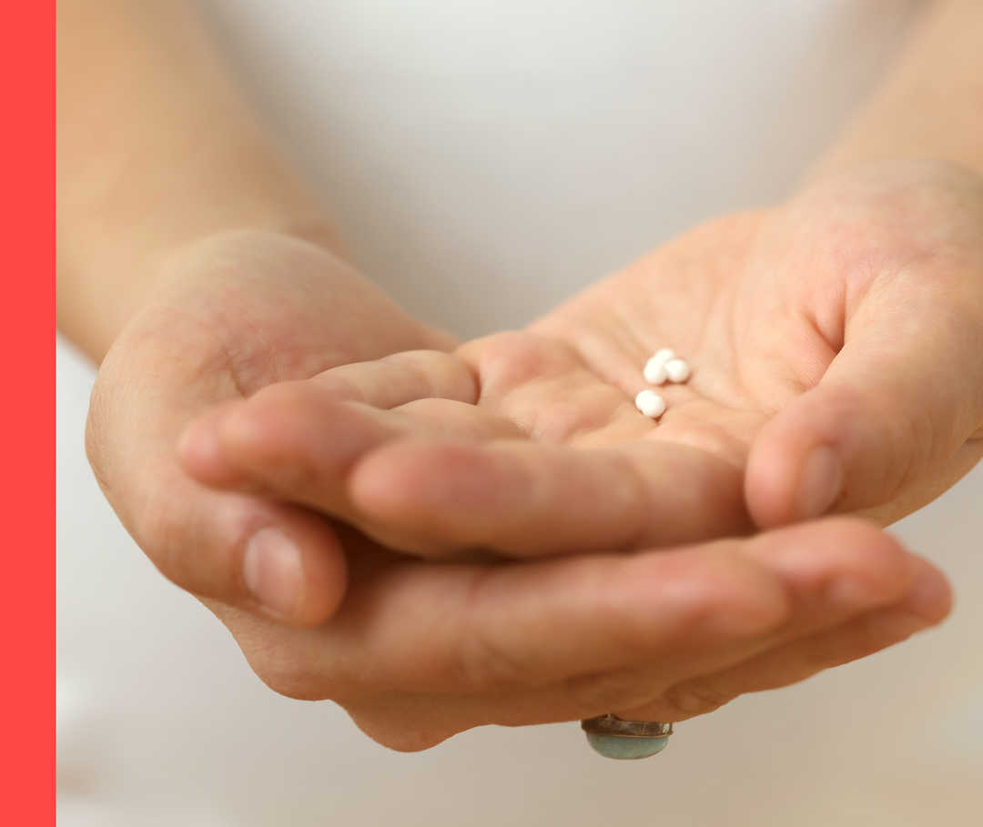 Homöopathie: Placeboeffekt Aufgehaltene Hände mit ein paar Globuli.