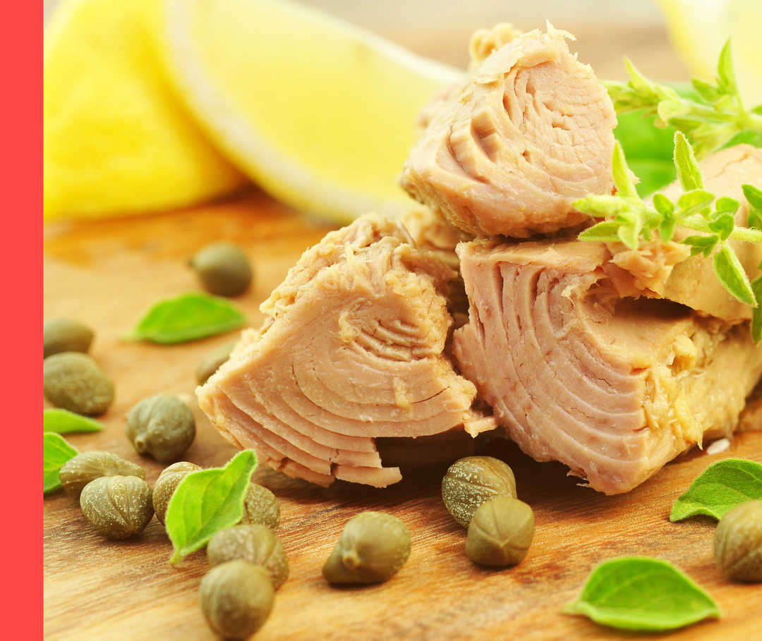 Psoriasis: Blitzschnell-Gericht Auf einem Holzbrett liegen Thunfisch, Kapern und Gewürze.