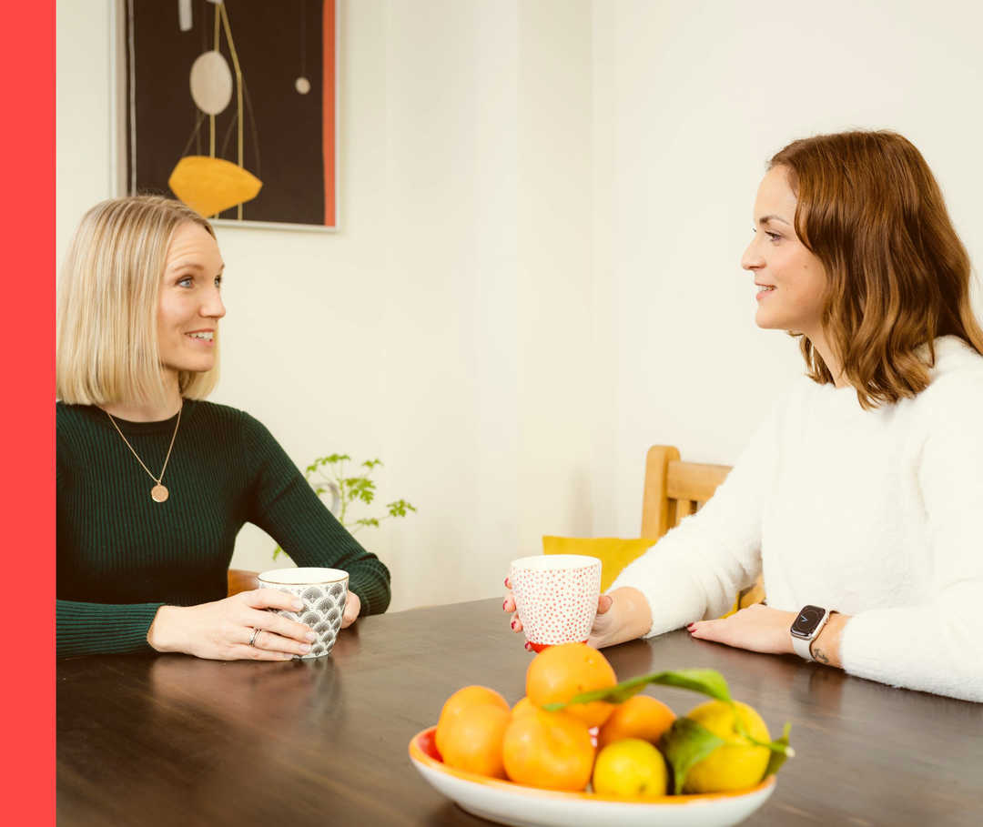Psoriasis-Patientenblog: Annas Antworten auf sechs Fragen zur Schuppenflechte Anna und Anna Lena sitzen zusammen an einem Tisch und unterhalten sich.