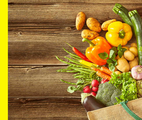 Aus einer Tasche quellen unterschiedliche Gemüsesorten.