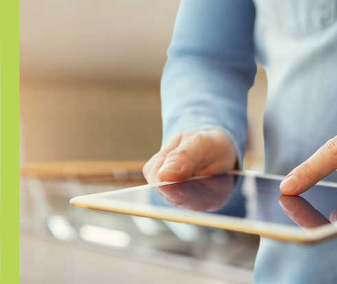 Eine Person tippt auf das Display eines Tablets.