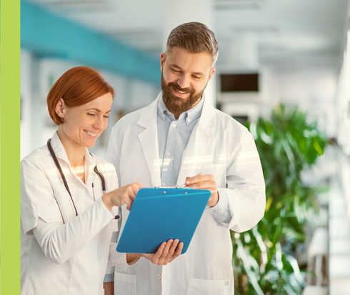 Eine Frau und ein Mann im weißen Kittel unterhalten sich.