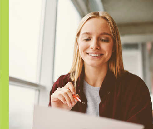 Eine junge Frau hält einen Stift in der Hand.