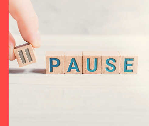 Holzwürfel mit der Aufschrift „Pause“.