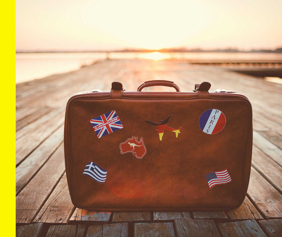 Nahaufnahme eines Koffers auf einem Steg im Sonnenuntergang.