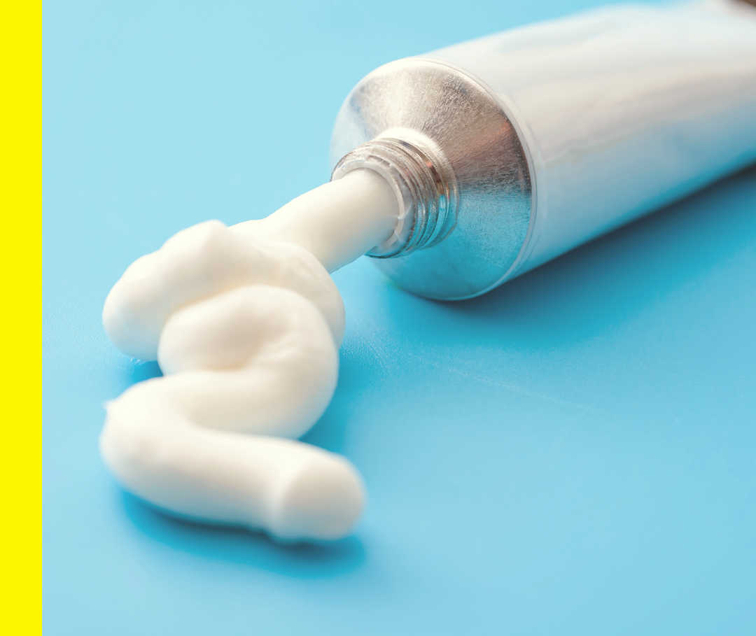 Eine Cremetube, aus der Creme gedrückt wird.