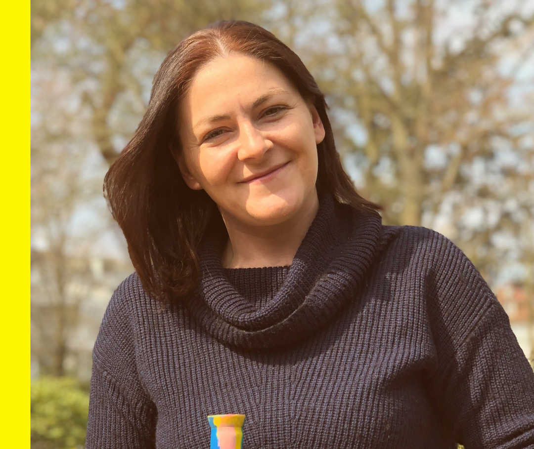 Ulrike lächelt im Sonnenschein in die Kamera. 