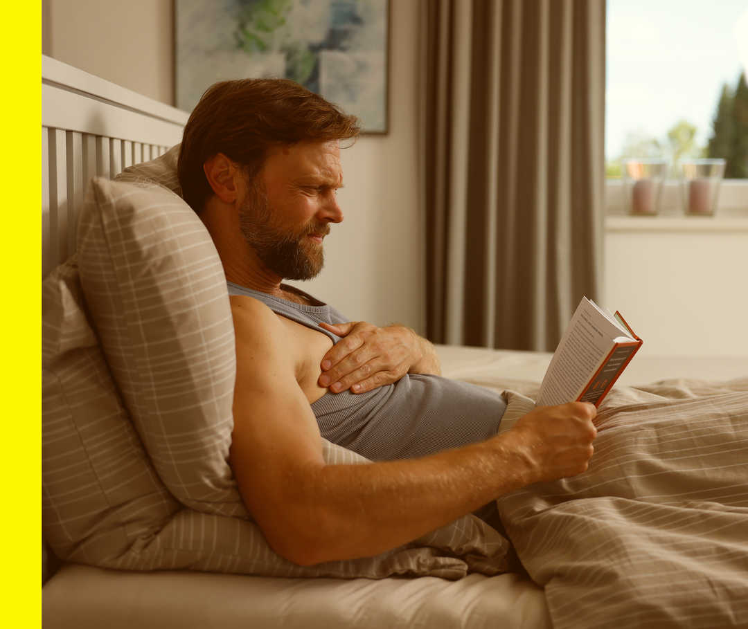 Ein Mann fasst sich an der Brust und hat Schmerzen.