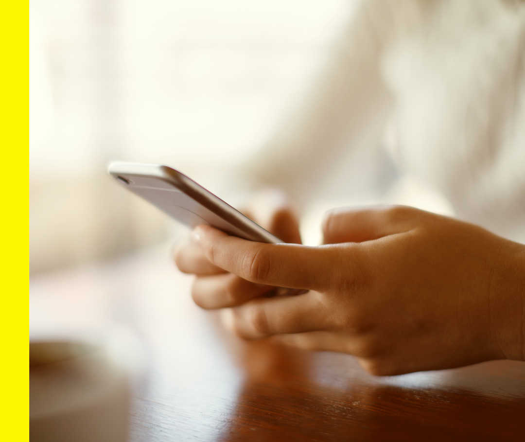 Nahaufnahme von zwei Händen, die ein Smartphone halten.