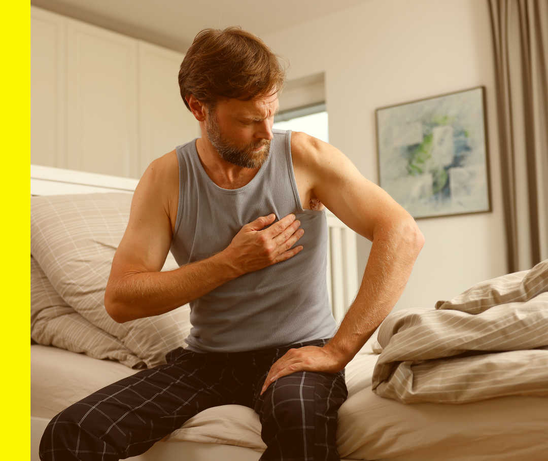 Ein Mann fasst sich an der Schulter