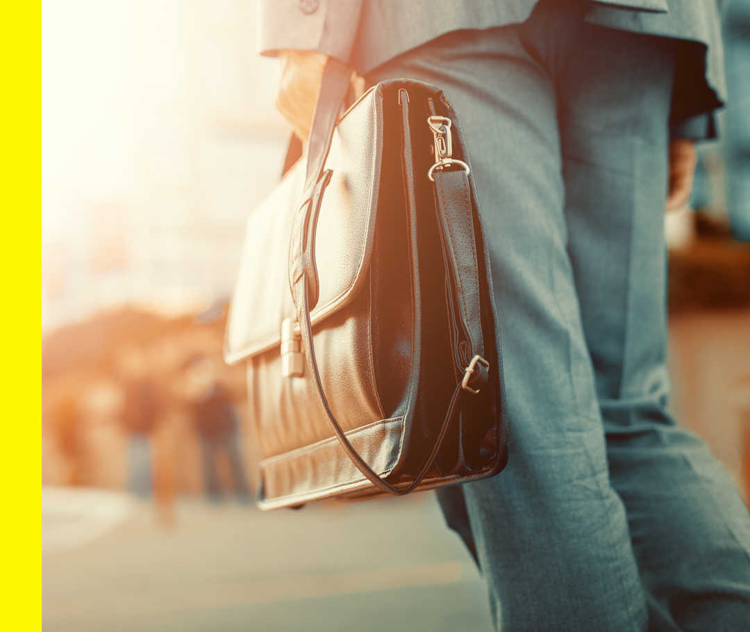 Ein Mann trägt eine Ledertasche.