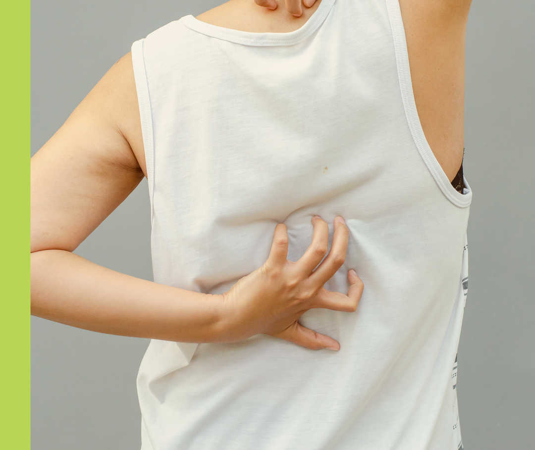 Nahaufnahme einer Hand, die einen bekleideten Rücken kratzt. 