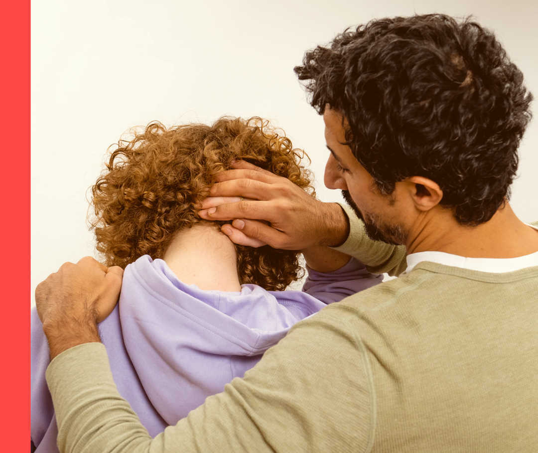 Ein Mann begutachtet den Nacken einer Frau.