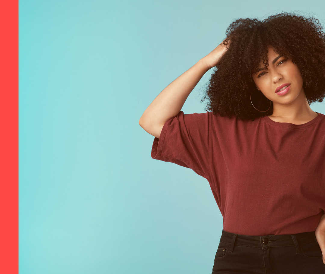 Eine Frau, die sich am Kopf kratzt.