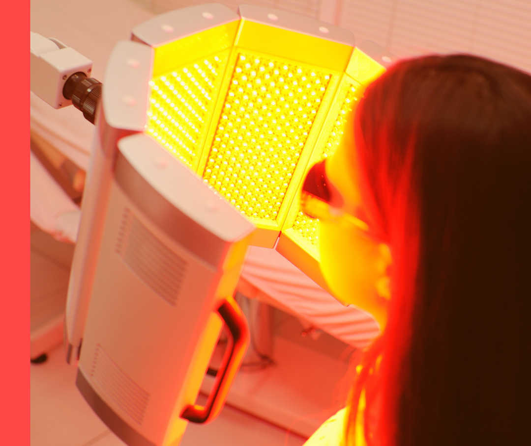 Hautwende erleben: altbewährte Lichttherapie bei Psoriasis Eine Person mit Schutzbrille sitzt vor einem Rotlicht-Gerät.