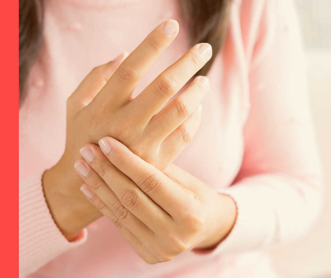 Nahaufnahme einer Person, die mit einer Hand an die Gelenke der anderen Hand fasst. 