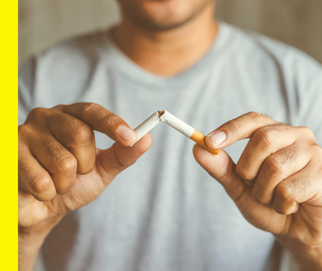 Ein Mann bricht seine Zigarette durch.