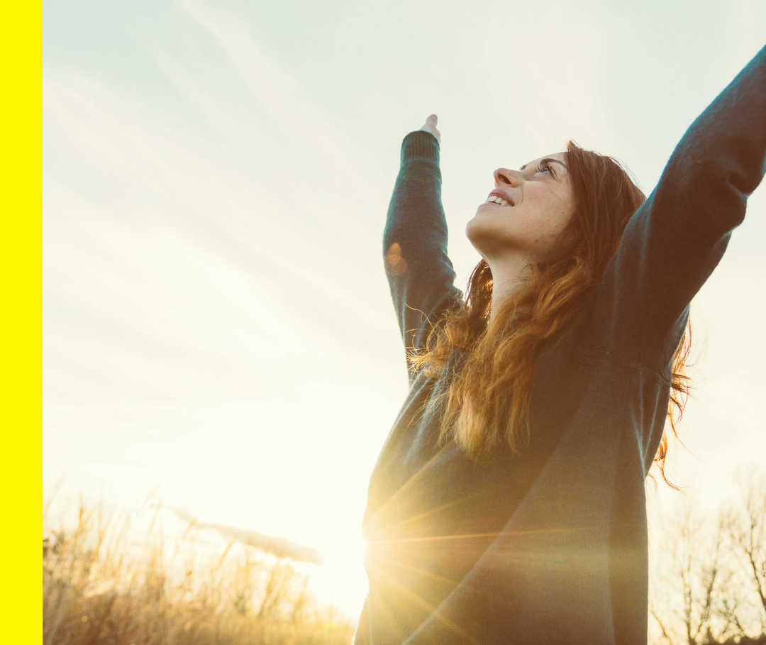 Eine Frau streckt beide Arme in die Luft.