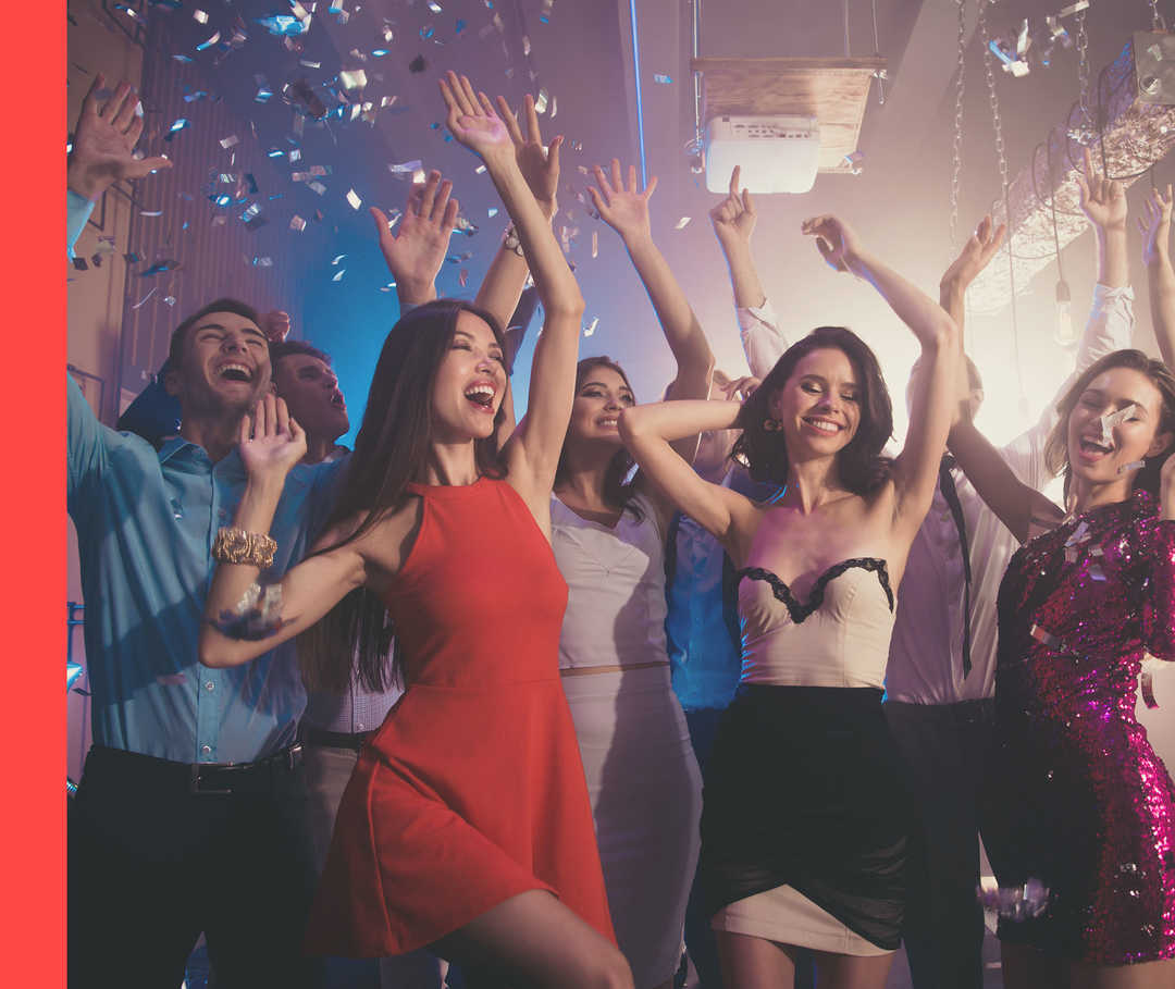 Eine Gruppe Menschen tanzt und es fällt Konfetti herab.