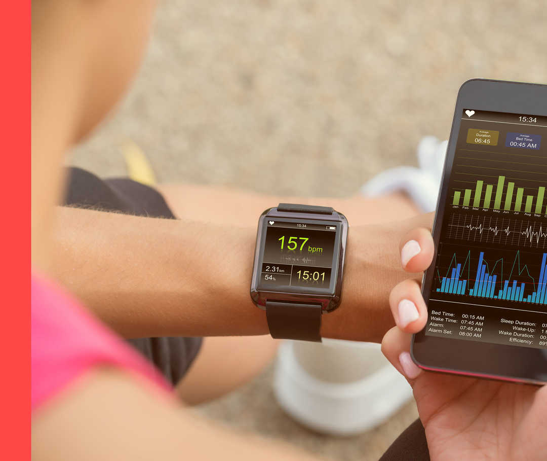 Eine Person hält in einer Hand ein Handy, an der anderen trägt sie eine Fitnessuhr.