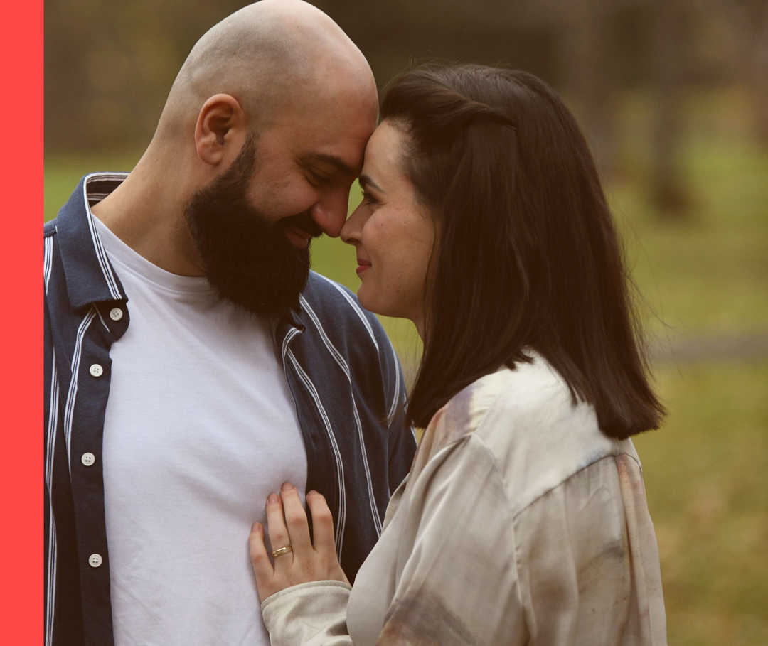 Sine und ihr Freund Umut stehen nah beieinander und schauen sich lächelnd tief in die Augen. 