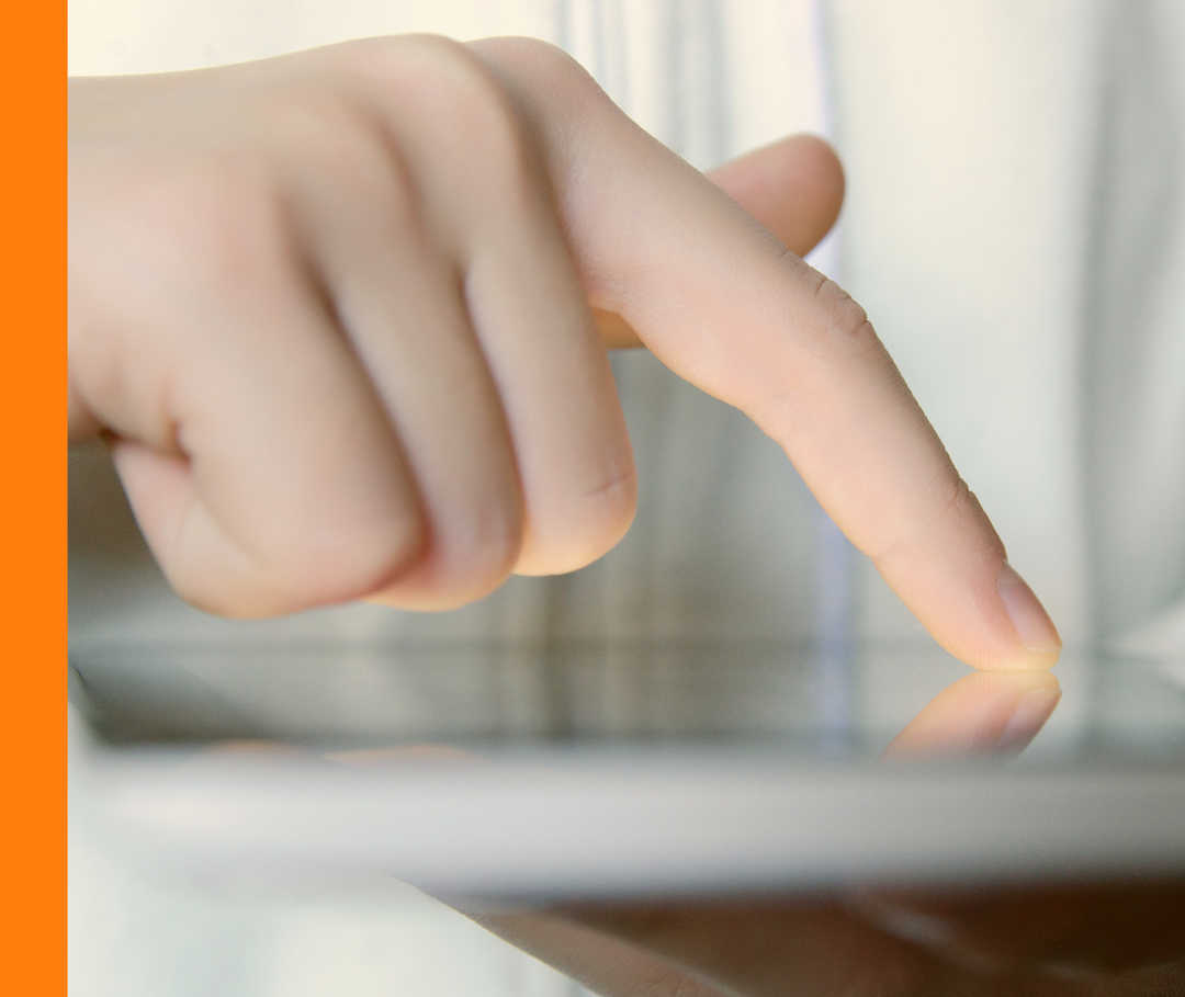 Eine Person hält einen Tablet-PC und wischt mit einem Finger über den Bildschirm.