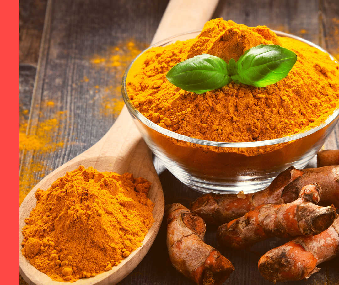 Ein Holzlöffel und eine Schale mit gelblich-orangen Gewürzpulver.