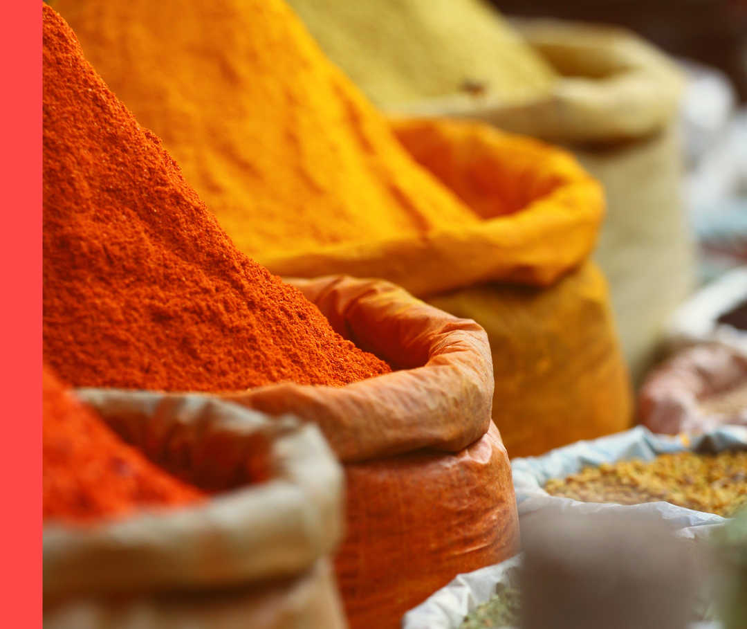 Vier Säcke mit verschiedenen Gewürzpulvern in gelblichen und rötlichen Farben.
