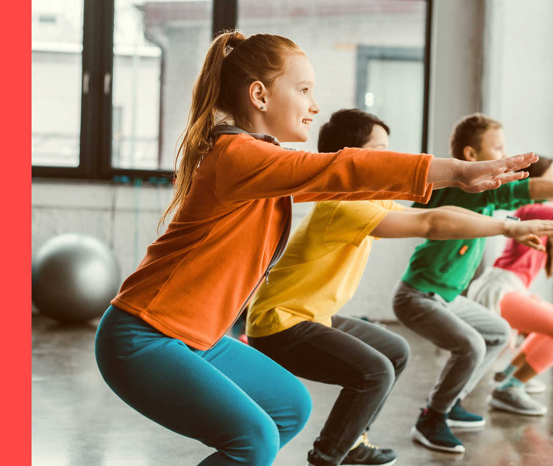 Mehrere Personen in Sportkleidung machen Kniebeugen in einer Sporthalle.