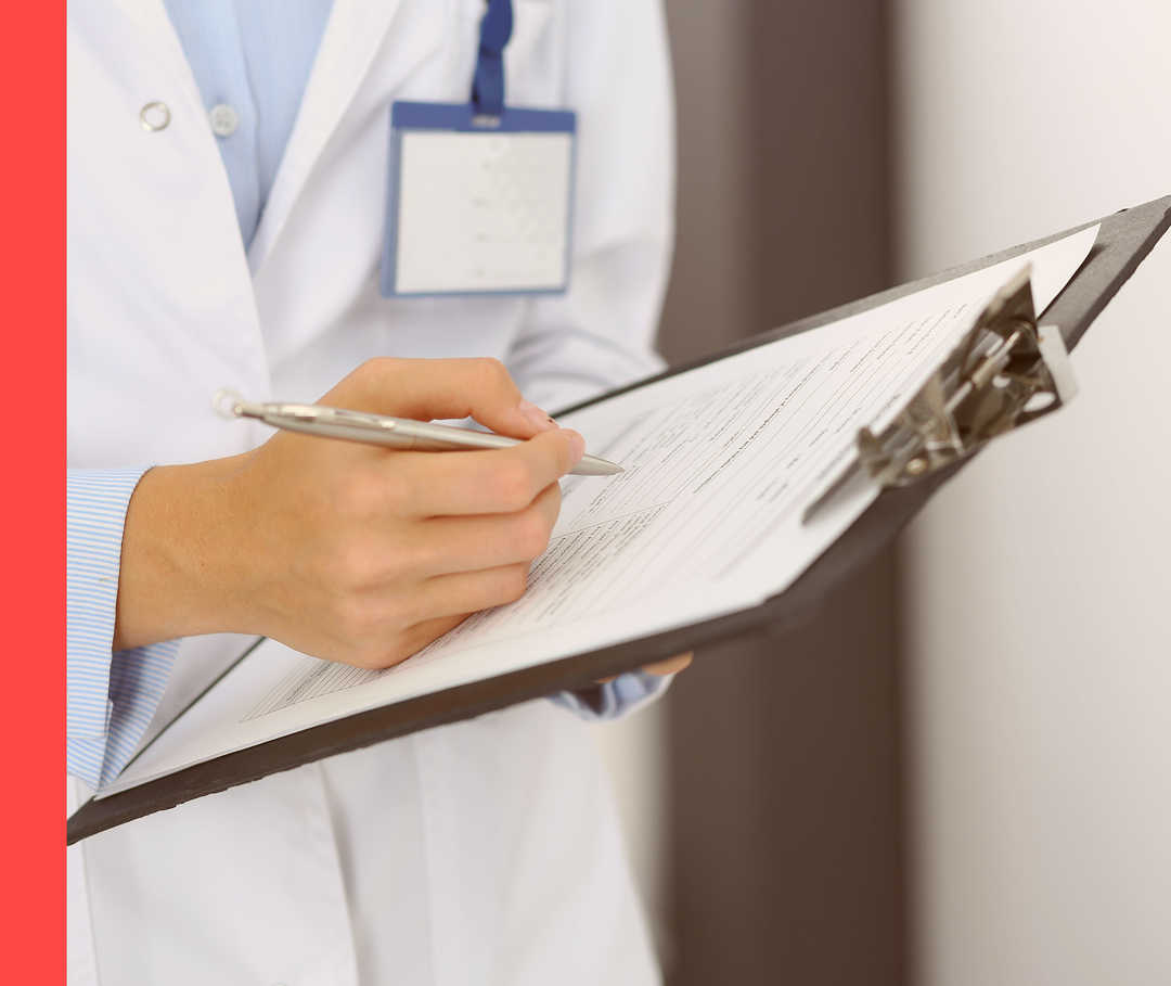 Eine Frau in einem weißen Kittel hält ein Klemmbrett mit einem Fragebogen.